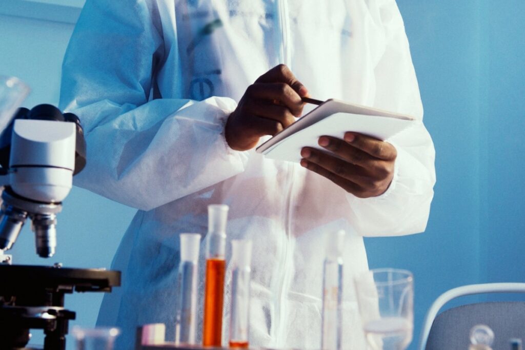 Man taking notes in a lab. Avoid documentation errors with good documentation practices.