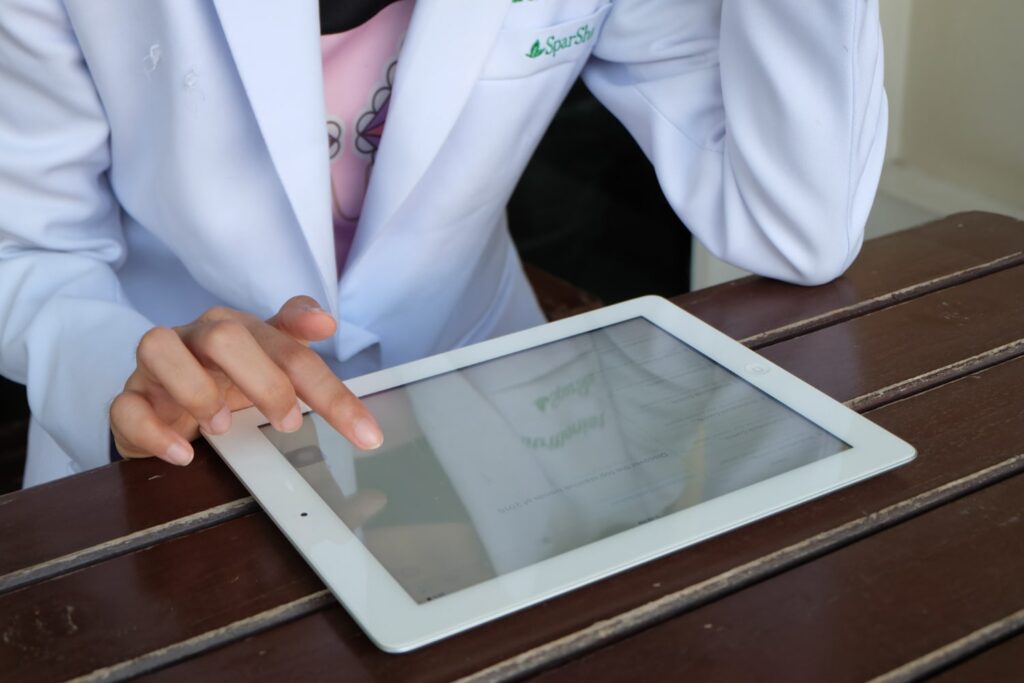 Scientist wearing a lab coat holding a table, using an Electronic Laboratory Notebook (ELN).